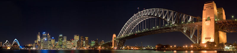 Evènements : Un panorama nocturne de Sydney Harbour, avec L'Opéra de Sydney sur la gauche, le centre des affaires en centre et l'Harbour Bridge sur la droite